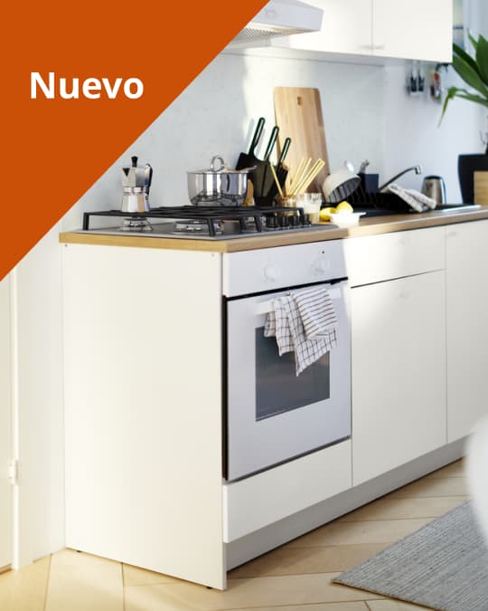 Una cocina con muebles blancos y un mesón efecto madera que tiene ollas y artículos de cocina a la vista.