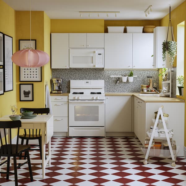 Una cocina con muebles de la serie ÄLMAREN. EL piso de la cocina es de cuadrillé blanco y terracota.