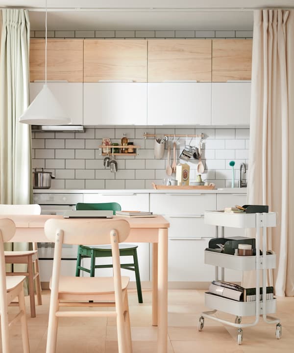 Una cocina de IKEA separada del espacio del comedor con dos cortinas.