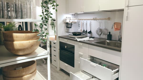Una cocina muy pequeña en el pasillo con soluciones de almacenaje de interior