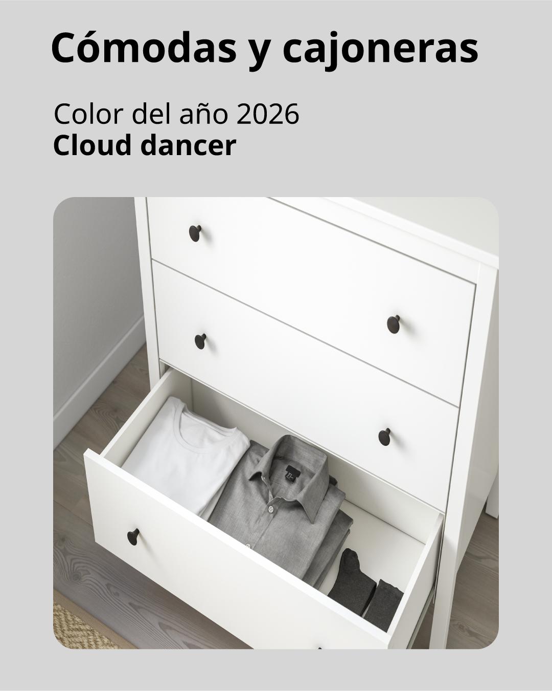 Una cómoda blanca de 3 cajones y el último abierto mostrando el espacio disponible para guardar ropa.