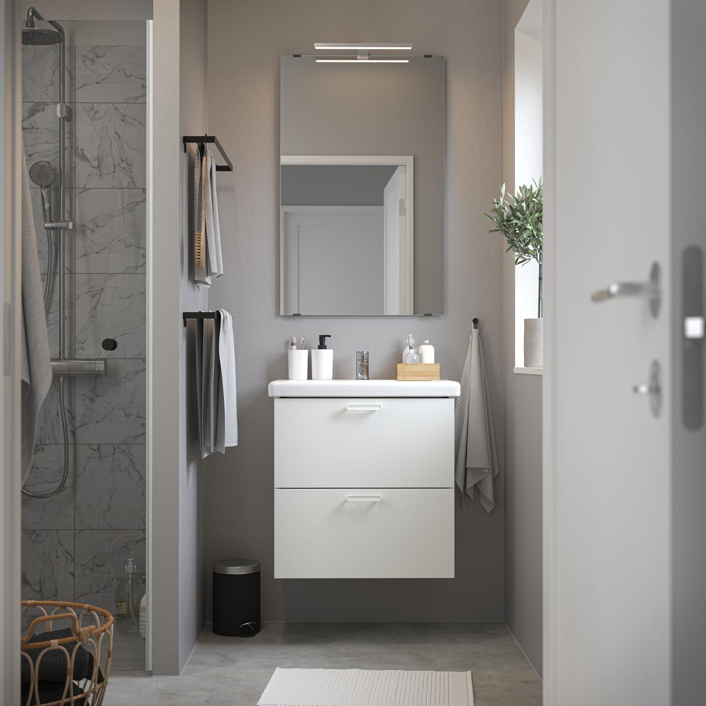 Una composizione bagno ENHET bianco visto frontalmente con specchio rettangolare e accessori per il bagno