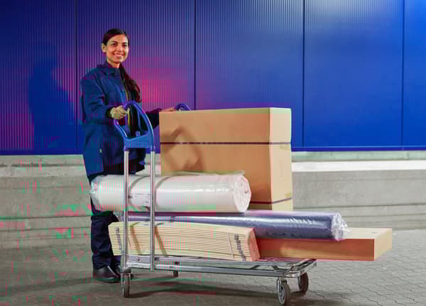 Una coworker IKEA con un carrello colmo di prodotti.
