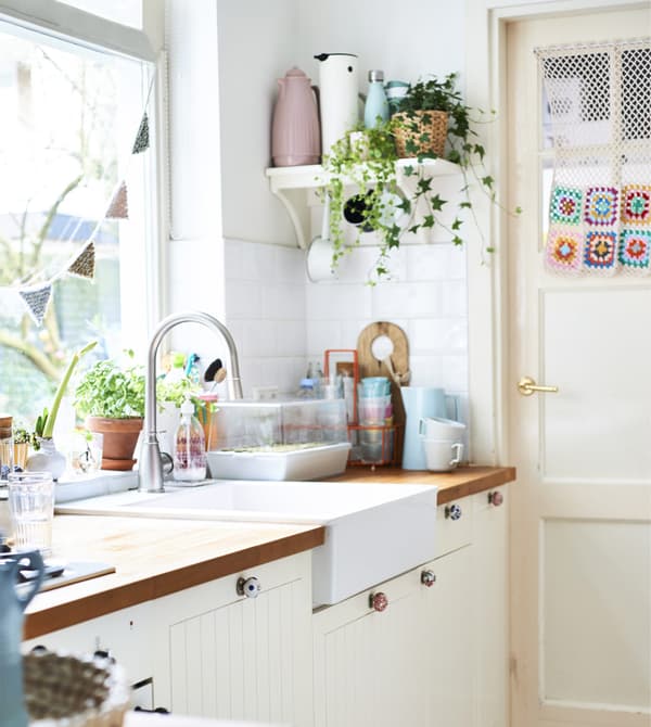 Una cucina bianca con vasi color pastello e piante su una mensola - IKEA