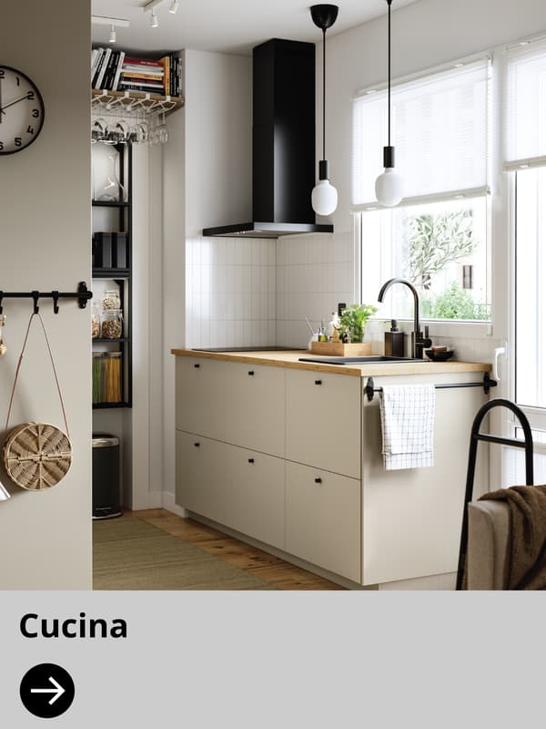 Una cucina chiara con cappa nera.