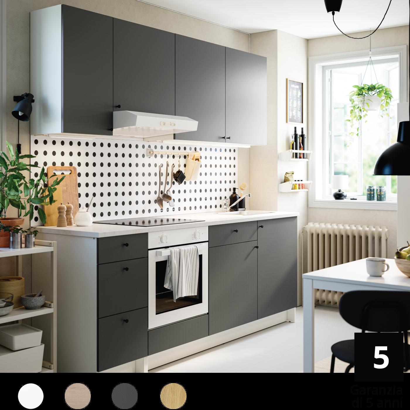 Una cucina KNOXHULT arredata di cassetti, pensili, tavolo, sedie e pannelli portaoggetti.