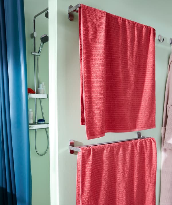 Una doccia dietro a una semiparete, sulla quale sono montati due portasciugamani - IKEA
