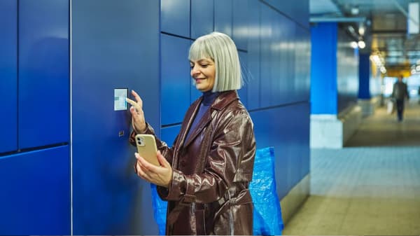 Una donna che sta ritirando i prodotti acquistai in IKEA da un locker