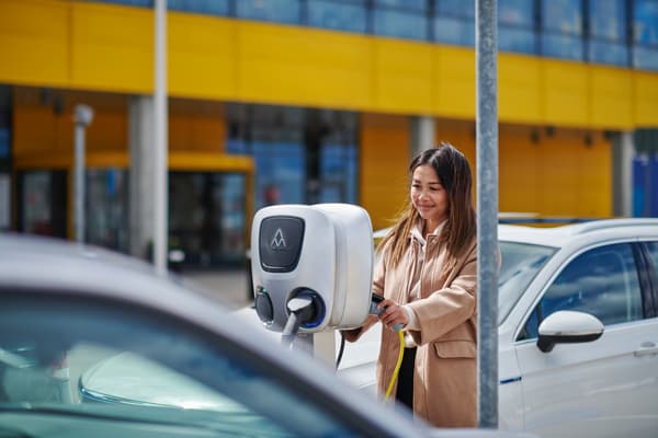 Una donna mentre sta collegando la macchina ad una colonnina elettrica nel parcheggio IKEA.