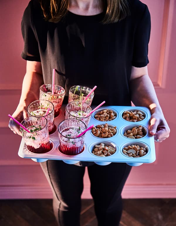 Una donna utilizza uno stampo per dolci come vassoio per drink e salatini - IKEA.