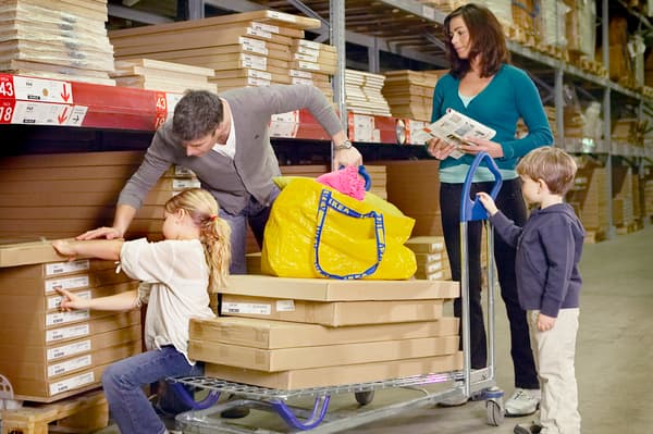 Una familia compuesta por una mujer, un hombre, una niña y un niño, eligiendo productos en una tienda IKEA.