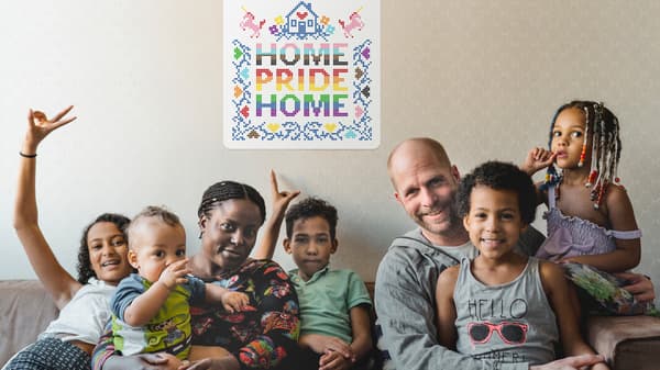 Una familia de dos padres y cinco hijos sentados en un sofá con un cartel de Home Pride Home en la pared detrás de ellos.