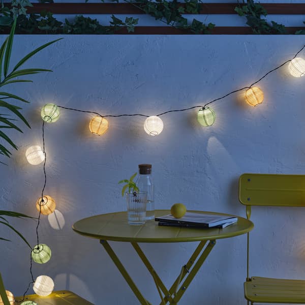 Una guirnalda solar encendida colocada en la pared sobre una mesa .