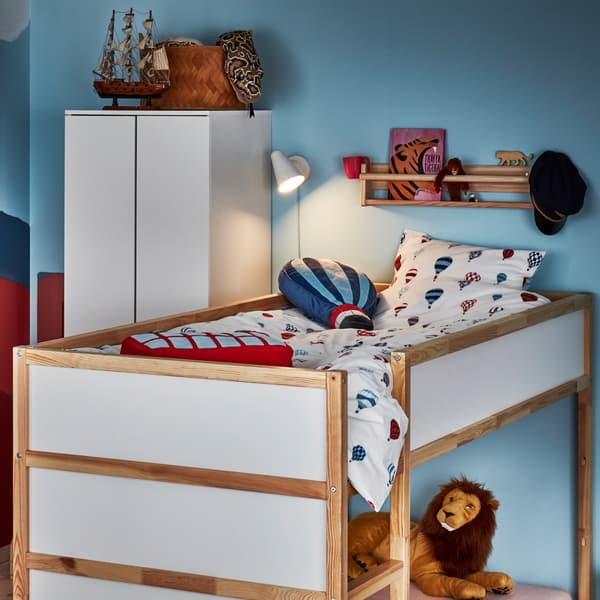 Una habitación infantil con una cama reversible KURA y textiles