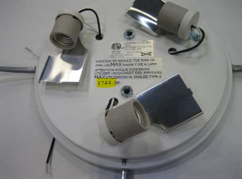 Una lámpara de techo sin pantalla, que deja al descubierto los tres casquillos de las bombillas eléctricas.