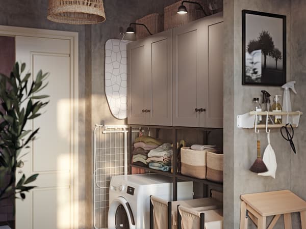 Una lavanderia con piastrelle gialle, un mobile NYSJÖN bianco con una lavatrice bianca e accessori in colori diversi - IKEA.