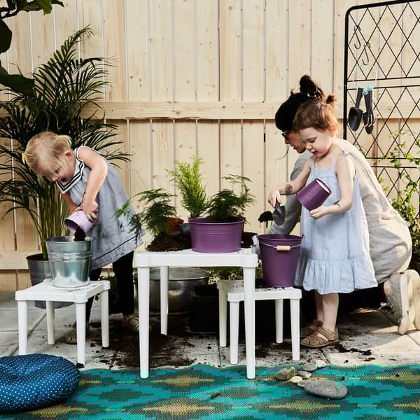 Una mamma e due bambine riempiono i vasi con la terra - IKEA.