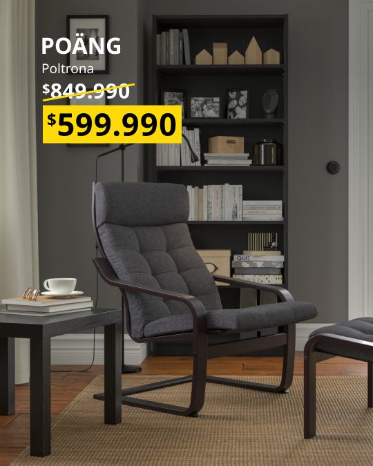 Una mecedora POÄNG con su apoyapiés en una sala con un librero.