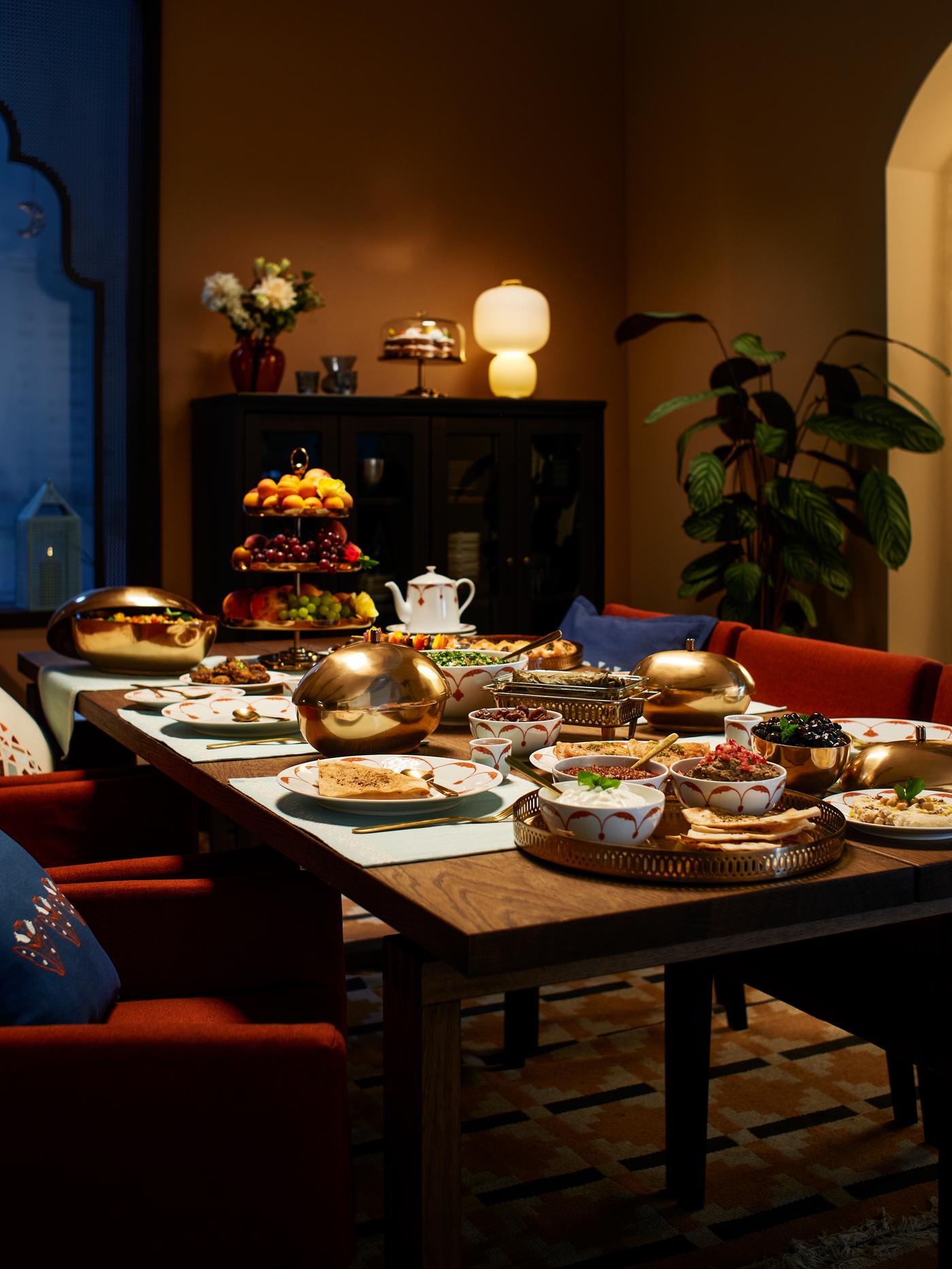 Una mesa con comida servida en la colección completa de accesorios para el hogar GOKVÄLLÅ.