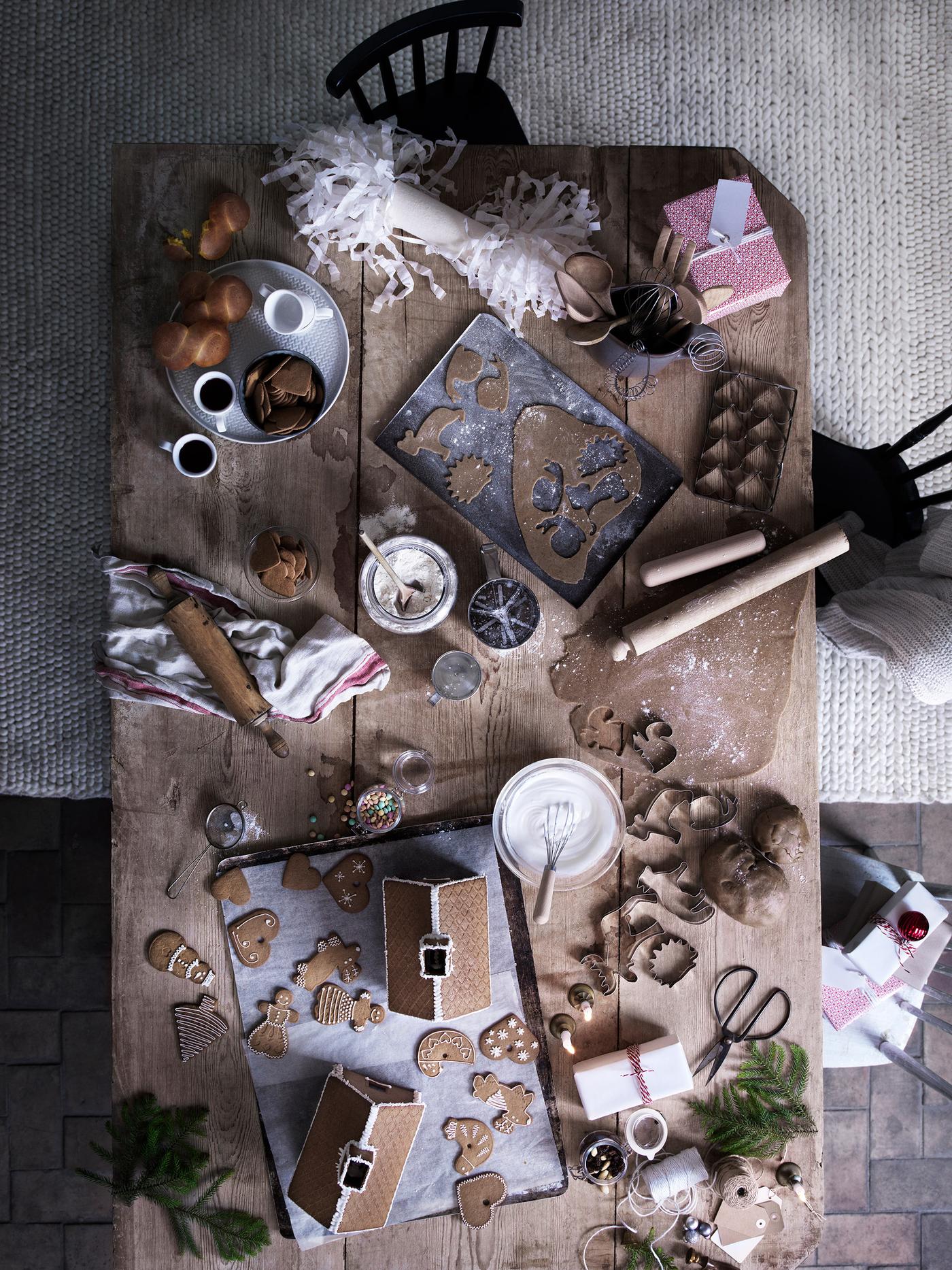 Una mesa con masa de galletas y muchos cortadores con motivos navideños.