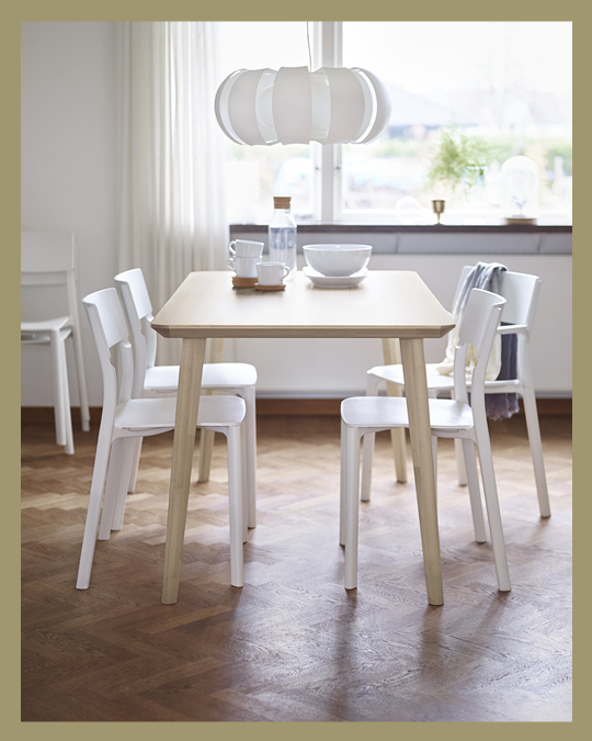 Una mesa de comedor LISABO con 4 sillas plásticas blancas.