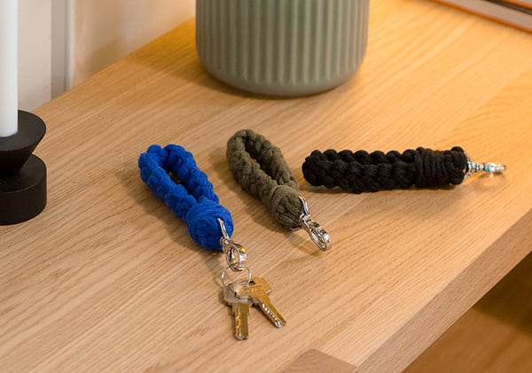 Una mesa en el recibidor con 3 llaves y sus respectivos llaveros de colores, azul, verde militar y negro.