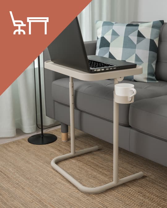 Una mesa para notebook BJÖRKÅSEN y en la parte superior de la imagen un ícono de escritorio con silla de escritorio sobre un triángulo naranjo.