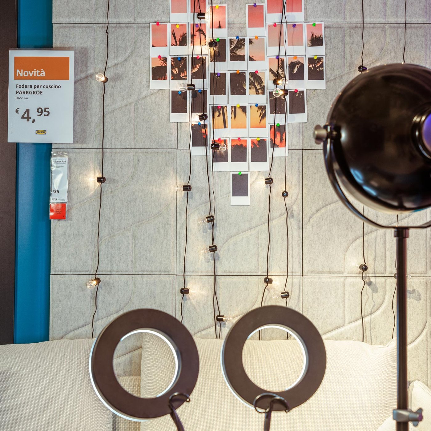 Una parete dotata di schermi acustici, decorata con fotografie collocate a formare un cuore e lucine decorative accese. Di fronte, sono collocate delle ring light e una luce.