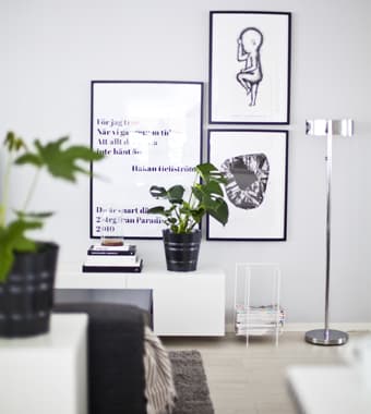 Una parete grigio chiaro decorata con quadri in bianco e nero.