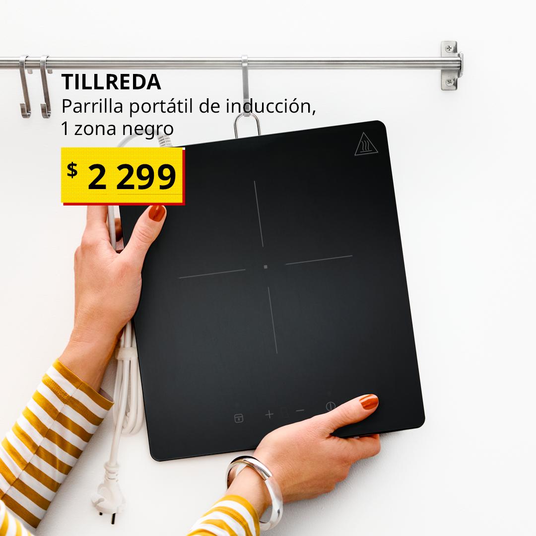 Una persona cuelga una parrilla de inducción portátil TILLREDA en un gancho de un riel.