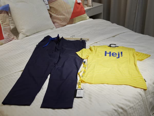 Una persona empenta una fila de carrets de la compra d'IKEA a una botiga IKEA.