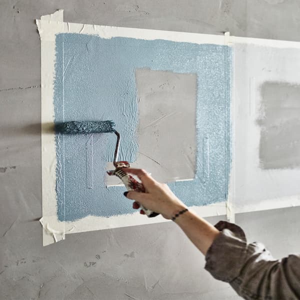 Una persona pintando una pared con rodillo