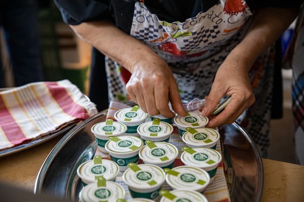 Una persona sta aprendo una piccola confezione di plastica su un vassoio su cui ce sono altre. 