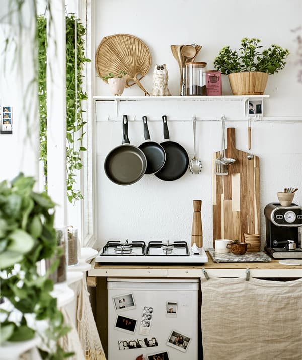 Una piccola cucina con un piano cottura, utensili appesi alla parete e una mensola – IKEA