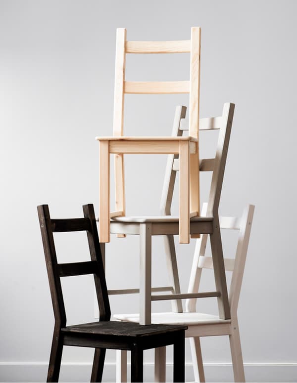Una pirámide de sillas IKEA IVAR, cada una de ellas barnizada o tintada de un color.