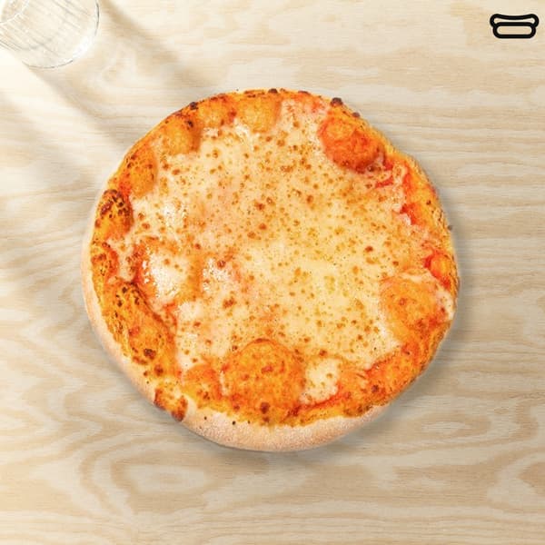 Una pizza margherita in un piatto bianco su un tavolo legno chiar