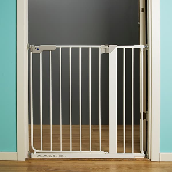 Una puerta blanca de seguridad para bebés colocada en una puerta con un piso de madera café.