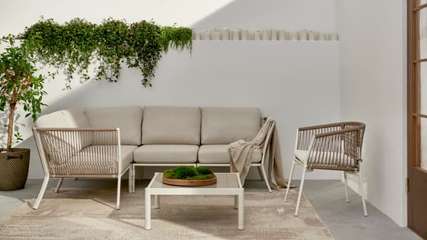 Una sala de exterior SEGERÖN con cojines en tono beige.