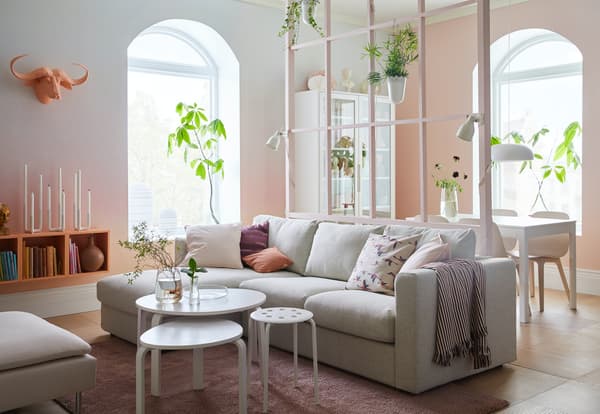 Una salotto con una chiase lounge VIMLE, tre sgabelli KYRRE, un tavolo bianco e 4 sedie beige.