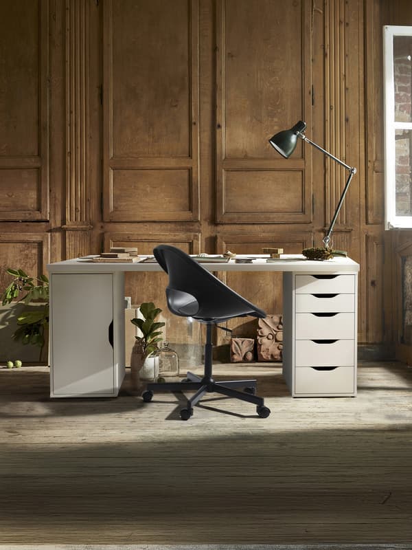 Una scrivania bianca con cassetti e ante laterali e una sedia da ufficio nera