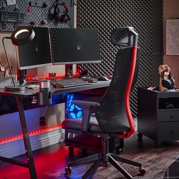 Una scrivania da gaming UTESPELARE nera con due monitor, una sedia da gaming nera, una cassettiera nera e vari accessori da gaming - IKEA.