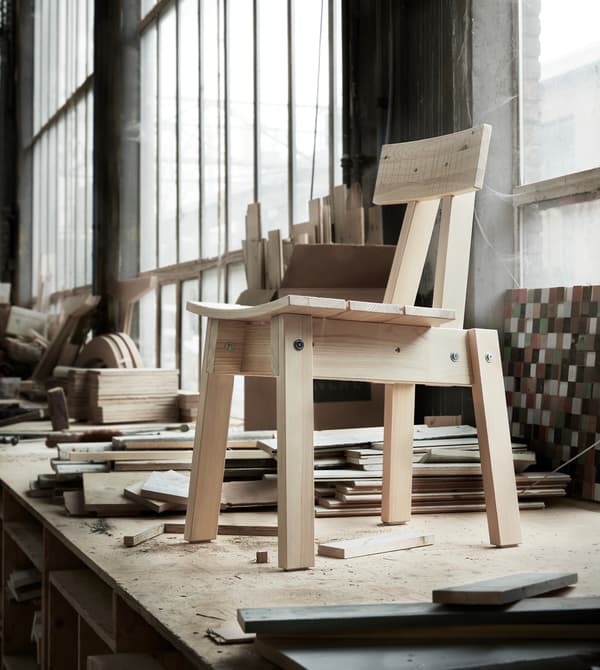 Una sedia in legno di pino su un piano di lavoro.