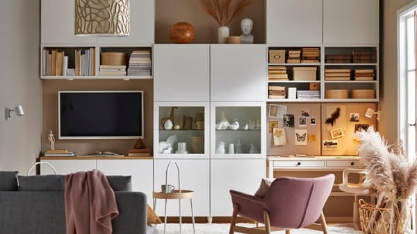 Una serie de estantes y muebles con puertas del sistema BESTÅ en un living.