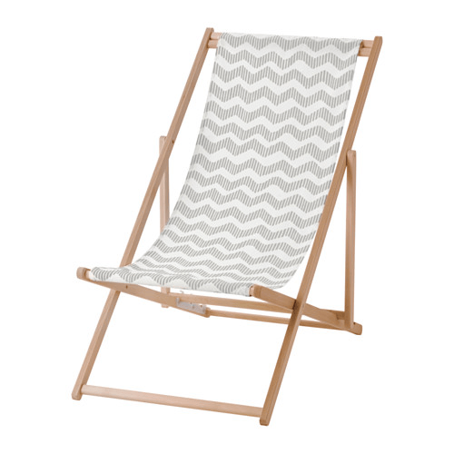 Una silla de playa plegable en madera con un asiento de tela estampada en gris y blanco.