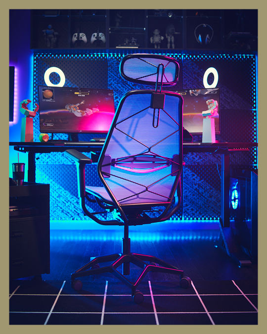 Una silla gamer frente a un pc con luces LED en tonos azules.