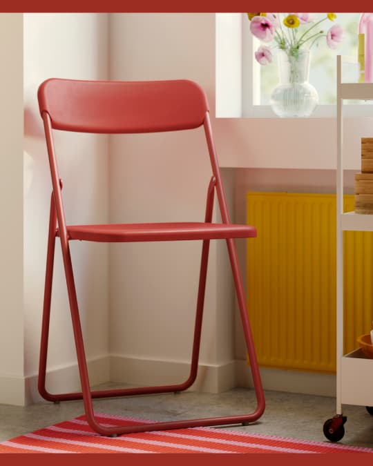 Una silla plegable roja sobre un tapete.