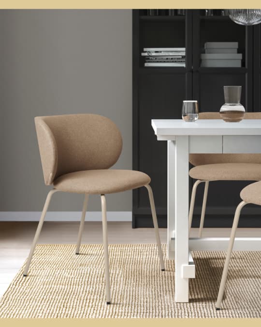 Una silla tapizada y acolchada color chocolate en la punta de una mesa de comedor rectángular.