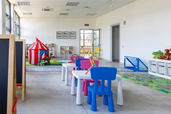 Una stanza con giochi, sedie e tavoli MAMMUT, tappeti STORABO, una tenda CIRKUSTÄLT in una struttura destinata ad ospitare donne e bambini ucraini.