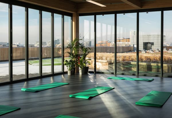 Una stanza con tappetini da yoga e finestre a tutta parete dalle quali si vede lo skyline di Londra - IKEA