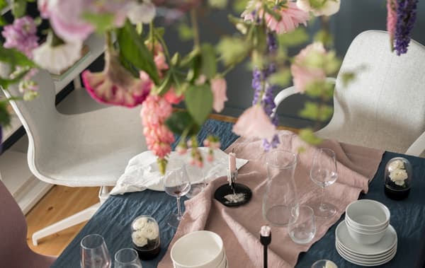 Una taula de menjador decorada per a un sopar especial, amb cadires d’oficina IKEA LÅNGFJÄLL que fan de seients per a convidats inesperats.